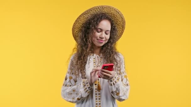 漂亮的乌克兰女人在智能手机上收到甜言蜜语或许多喜欢的东西 在黄色背景上笑着和快乐的女孩 社交网络的概念 高质量的4K镜头 — 图库视频影像