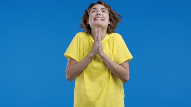 きれいな女性が祈り 彼女を謝罪し始め 彼女は有罪です 青の背景 誰かに願いを叶え 助けを求める希望的な祈り 高品質4K映像 — ストック動画