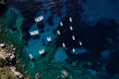 Akdeniz 'deki deniz suyunu temizlemek için havadan helikopter manzarası, demirli tekneler ve yatlar. Yunanistan 'ın Corfu Adası' ndaki özel plajda demirleme sahaları