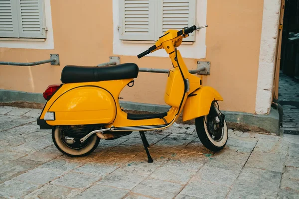 Sarı retro scooter eski binanın yakınında. Motosikletin güzel klasik tasarımı. Yüksek kalite fotoğraf
