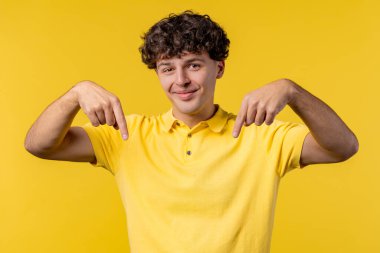 Reklam alanına bakan mutlu adam. Sarı arka plan. Genç adam aşağıya üye olmak için tıklamak istiyor. Ticari fikrin için yer kopyala, promosyon içeriği. Yüksek kalite fotoğraf