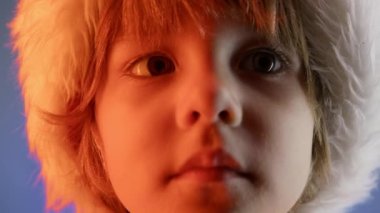 Mavi stüdyo arka planında Noel Baba şapkalı küçük bir çocuğun portresi. Noel kutlaması. Mutlu bir çocukluk geçir evlat, sevgili oğlum. Yüksek kalite 4k görüntü