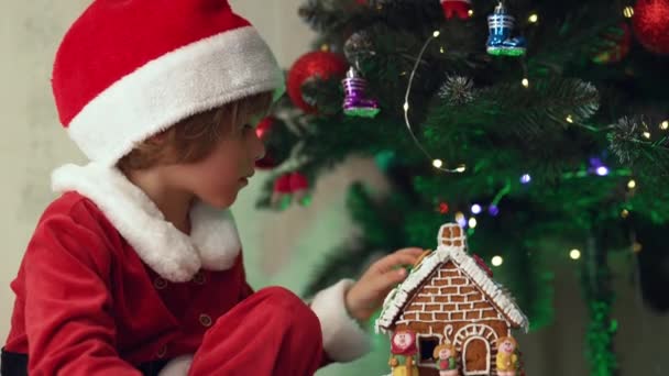 Χαριτωμένο Μικρό Αγόρι Κοστούμι Άγιος Βασίλης Κάθεται Μελόψωμο Σπίτι Στο — Αρχείο Βίντεο