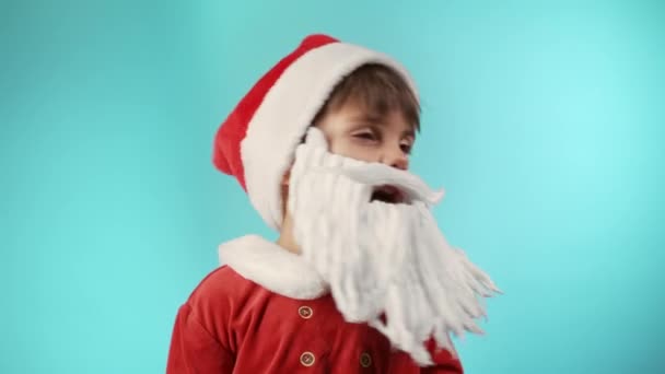 穿着圣诞老人服装的小男孩 留着胡子 不赞成 没有头信号 点头表示不赞成 不同意 蓝色的圣诞背景高质量的4K镜头 — 图库视频影像