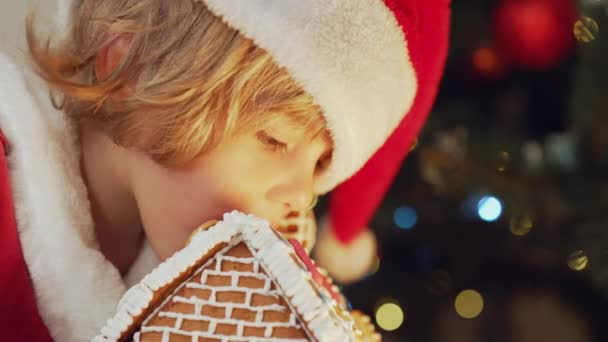 Słodki Chłopczyk Kostiumie Świętego Mikołaja Jedzący Pierniki Tle Choinki Świętowanie — Wideo stockowe