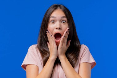 Hayret bir kadın, çığlık atıyor. Dikkat çekmeye çalışan etkileyici bir genç. Satış kavramı, karlı bir teklif. Mavi arka plandaki heyecanlı mutlu kız. Yüksek kalite fotoğraf