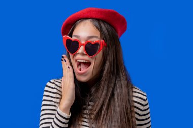 Hayret bir kadın, çığlık atıyor. Dikkat çekmeye çalışan bereli ve gözlüklü şık bir bayan. Satış kavramı, karlı bir teklif. Mavi arka plandaki heyecanlı mutlu kız. Yüksek kalite fotoğraf