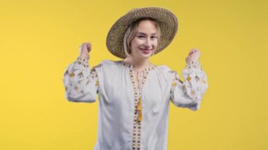 Pretty ukrainian woman makes hand sign like, thumbs up gesture. Happy girl, correct perfect choice, great deal, yellow background. Positive lady smiles to camera, approval, trust concept. 4k footage
