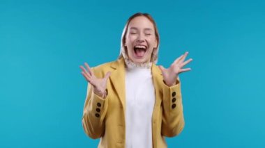 Shocked woman glad, she screaming WOW. Impressed lady trying to get attention. Concept of black friday sales, profitable offer. Excited happy businesswoman on blue background. High quality 4k footage