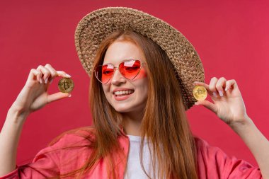 Woman with bitcoin, crypto currency. Golden coins, pink background. Digital exchange, popularity of BTC, symbol of future money, electronics industry, mining concept. High quality photo