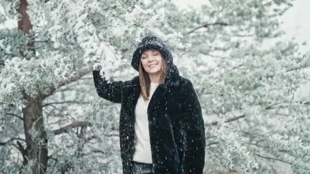 Stylish Woman Fluffy Bucket Hat Pulls Branch Tree Snow Flies — Stockvideo