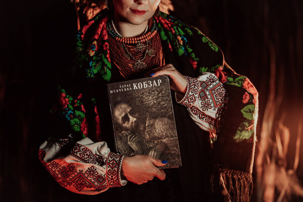 Женщина, держащая Кобзаря - сборник стихов Тараса Шевченко - поэт, бард в украинской культуре.