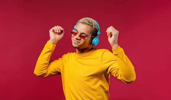 积极的美国男人听音乐 喜欢用红色录音室背景的耳机跳舞 无线电 无线现代音响技术 在线播放器 高质量的照片 — 图库照片