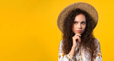 Sarı arka planda dalgın bir Ukraynalı kadın. Akıllı öğrenci kızın cevap jesti bulması ya da unuttuğu şeyi hatırlaması, hafıza konsepti. Yüksek kalite fotoğraf