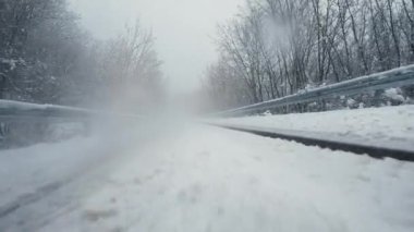 Kırsal kesimde kış inanılmaz bir doğa. Aşırı açı. Arabayla seyahat, macera konsepti. Otomobil hızlandıktan sonra düşen kar dans ediyor.