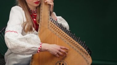 Geleneksel Ukraynalı, bandura pandora ya da kobza çalan bir kadın. Millet, müzikal konsept. Bayan nazikçe iplere dokunuyor. Yüksek kalite 4k görüntü
