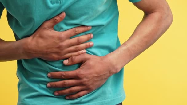 腹部の痛みのために腹の手を絞るアフリカ系アメリカ人男性 胃の痛みを患っています 腸の鼓腸の概念 高品質4K映像 — ストック動画