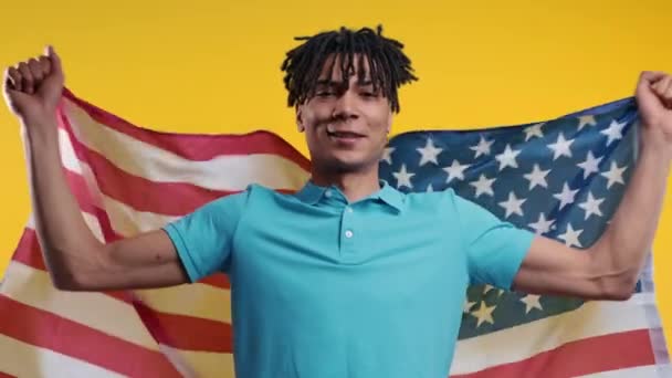 アフリカ系アメリカ人の国旗を持つ幸せな男 アメリカの愛国者 7月4日 独立記念日のお祝い アメリカ アメリカのバナー 高品質4K — ストック動画