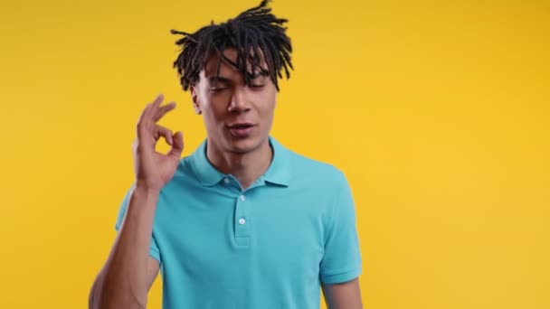 肯定的なアフリカ系アメリカ人の男はOkの手の署名 Okジェスチャーを行います 幸せな学生の男 正しい完璧な選択 大きな取引 黄色のスタジオの背景 高品質4K — ストック動画