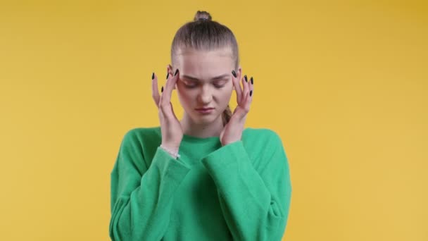疲れて女性のマッサージ寺院 黄色の背景に頭の痛み 10代の少女は頭痛に苦しんでいる 偏頭痛の概念 — ストック動画