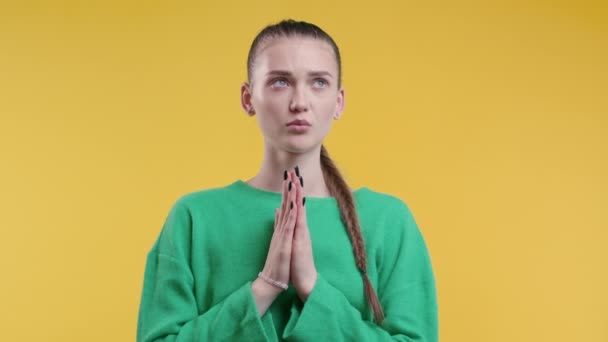 黄色の背景に調和を祈る若い女性 女の子は人 子供を救うために神を懇願します 宗教の概念 高品質4K — ストック動画