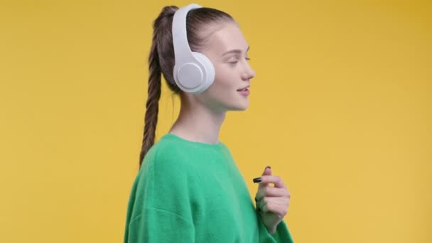 Szczęśliwy Nastolatek Słuchający Muzyki Cieszący Się Tańcem Słuchawkami Żółtym Tle — Wideo stockowe