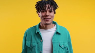 Şok olmuş Afro-Amerikan adam sevindi, çığlık attı. İlgi çekmeye çalışan etkileyici bir adam. Kara Cuma satışları kavramı, karlı bir teklif. Sarı arka planda heyecanlı bir mutluluk. Yüksek kalite 4k