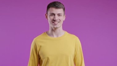 Dost canlısı adam evet işareti veriyor, başını sallıyor, onaylıyor. Olumlu gülümseyen adam, vücut dili. Doğru mükemmel seçim, harika bir anlaşma. Pembe stüdyo arka planı.