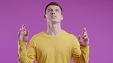 Genç adam menekşe arka planda dua ediyor. Adam birine arzularını tatmin etmesi için yalvarıyor, yardım ediyor, sınavda şans için dua ediyor. Yüksek kalite 4k görüntü