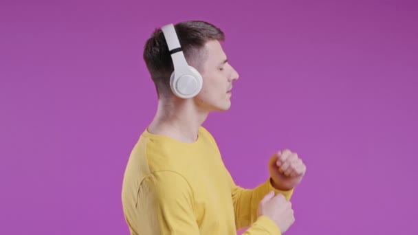 Pozytywny Młody Człowiek Słuchający Muzyki Cieszący Się Tańcem Słuchawkami Fioletowym — Wideo stockowe
