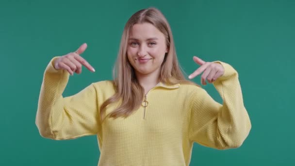 Блондинка Вказує Вниз Рекламної Зони Зелений Фон Молодий Блогер Просить — стокове відео