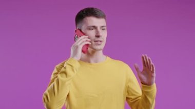 Sinirli genç adam cep telefonuyla konuşurken tartışıyor. Kızgın adam, stres. Violet stüdyo geçmişi. Çatışma, anlaşmazlık, olumsuz. Yüksek kalite 4k görüntü
