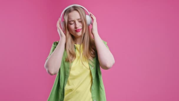 Красивая Женщина Слушает Музыку Наслаждаясь Наушниками Розовом Студийном Фоне Радио — стоковое видео