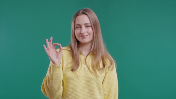 きれいな女性は手のサインを大丈夫 Okジェスチャーを行います 幸せな女の子 正しい完璧な選択 大きな取引 緑の背景 肯定的な女性モデルは カメラ 信頼の概念に笑顔 品質4K — ストック動画