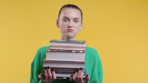 懒惰的女生或学生对黄色背景的大量书本作业感到不满 女孩很不高兴 她很恼怒 对学习感到沮丧 高质量4K — 图库视频影像