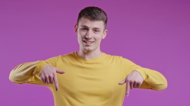 Щасливий Чоловік Вказує Вниз Рекламної Зони Фіолетовий Фон Молодий Хлопець — стокове відео