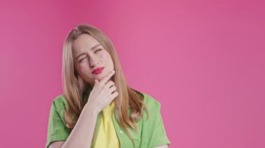 Mutlu kadının fikir üretme anı, pembe arka planı işaret ediyor. Akıllı bir bayan cevap veriyor ya da ne unuttuğunu hatırlıyor, hafıza konsepti. Yüksek kalite 4k