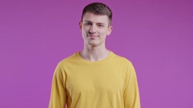 Kafa işareti olmadan onaylamayan ciddi bir adam, onaylanmayacak şekilde başını sallıyor. Reddetmek, reddetmek, anlaşmazlık, pembe arka planda genç bir adamın portresi. Yüksek kalite 4k görüntü