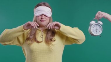 Mavi arka planda çalar saati olan gülümseyen bayan. Sabah erken, rutin bir gün, anı yaşamak, hayatın her dakikasının kıymetini bilmek, gençlik, uyanış. Yüksek kalite 4k