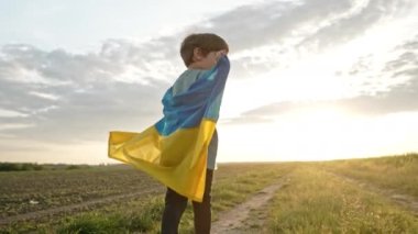Mutlu küçük çocuk, Ukraynalı vatansever çocuk serbest kırsal yolda, açık alanda ulusal bayrak sallıyor. Ukrayna, barış, bağımsızlık, özgürlük, savaşta kazanmak.
