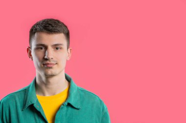 Renkli kıyafetli şık yakışıklı bir adamın portresi. Pembe stüdyodaki yakışıklı adam. Uzayı kopyala Yüksek kalite fotoğraf