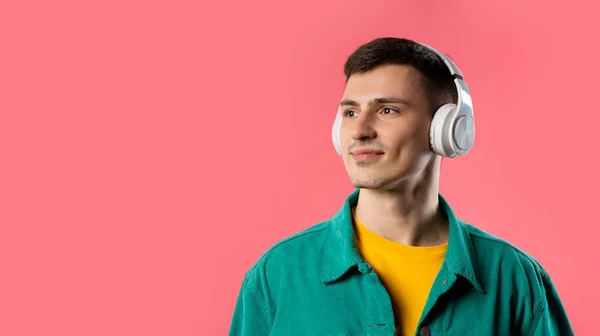 Positive Young Man Listening Music Enjoying Dance Headphones Pink Studio — Stock Photo, Image