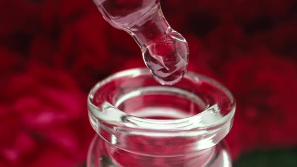 瓶装玫瑰精油 生产液体香气血清提取物 粉红清澈的水滴从管道滴入玻璃容器 摘要护肤产品 4K镜头 — 图库视频影像