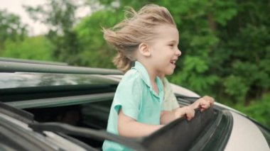 Sevimli mutlu küçük çocuklar yazın kırsal kesimde yol gezisi sırasında açık araba sunroof 'unda duruyorlar. Aile eğlencesi kavramı, aktif seyahat. Yüksek kalite 4k. 