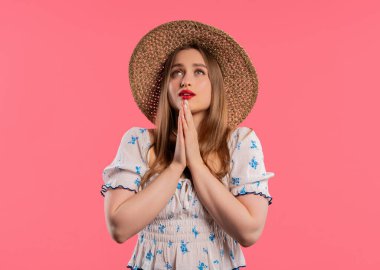 Genç bir kadın dua ediyor, özür diliyor, o suçlu. Pembe arka plan. Umut dolu dua eden kız, birinden arzularını tatmin etmesini ister, yardım ister. Yüksek kalite