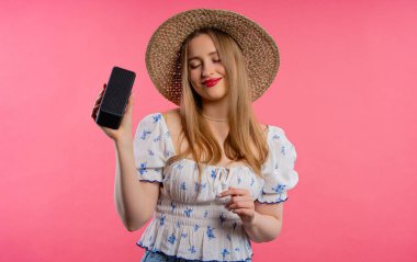 Dans eden bir bayan, pembe stüdyo arka planında eğleniyor. Müziğin ritmine göre hareket ediyor. Kablosuz taşınabilir hoparlörden müzik dinleyen genç bir kadın. Modern ses sistemi. - Evet. Yüksek kalite fotoğraf