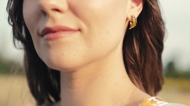 麦田里 一个漂亮的女人 戴着金耳环 站在外面 特写珠宝细节 高质量的4K镜头 — 图库视频影像