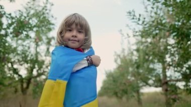 Yakışıklı küçük çocuk. 4 yaşında Ukraynalı vatansever çocuk açık gökyüzünde milli sarı bayrak taşıyor. Ukrayna, barış, bağımsızlık, özgürlük, gelecek nesil.