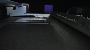 VCR VHS mekanizması içinde, video kaset oynatıcı, manyetik kafa. Döndürme makarasında video kaset var. Son derece makro görüntüler. Sinema kaydırma arkaplanı.