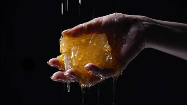 Bal dolu bal petekleri olan kadın eli. Damlayan, tatlı sıvı döken. Kalın altın akan nektar. Yüksek kalite fotoğraf